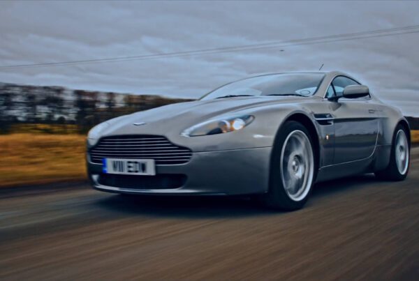 aston martin on road running from front left angle a quatre.