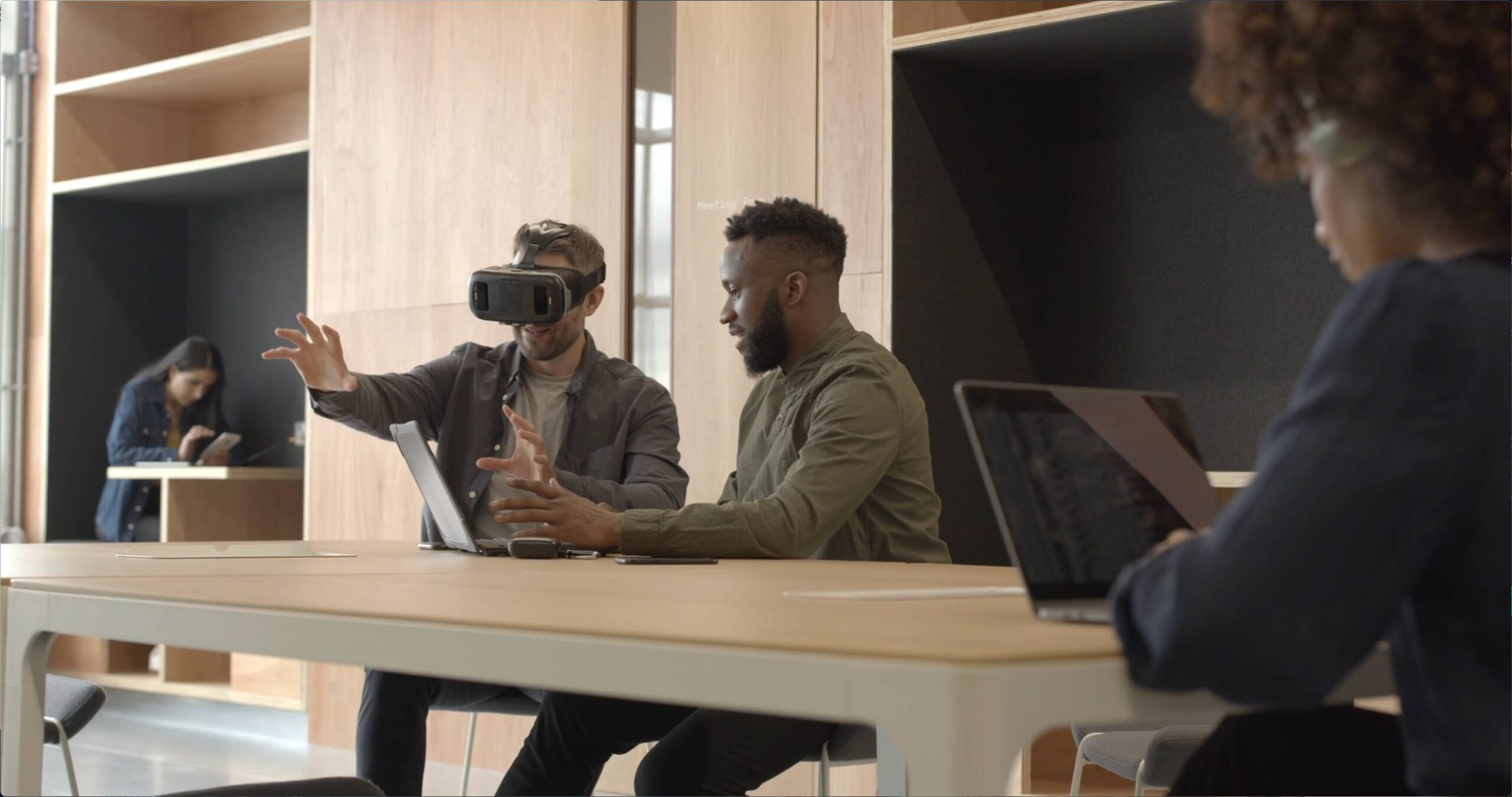 men sitting at table with laptop and vr headset | Lumira Studio Video Production Hertfordshire
